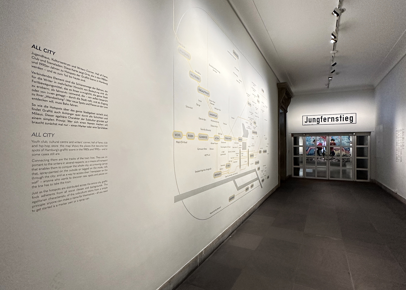 Der Eingangsbereich der Ausstellung " Eine Stadt wird bunt" im Museum für Hamburgische Geschichte. Eine Wand im Flur auf der das Hamburger U- und S- Bahn Netz zusehen ist – allerdings nicht mit den üblichen Bahnhöfen, sondern mit wichtigen Orten der Hamburger Graffiti Geschichte.